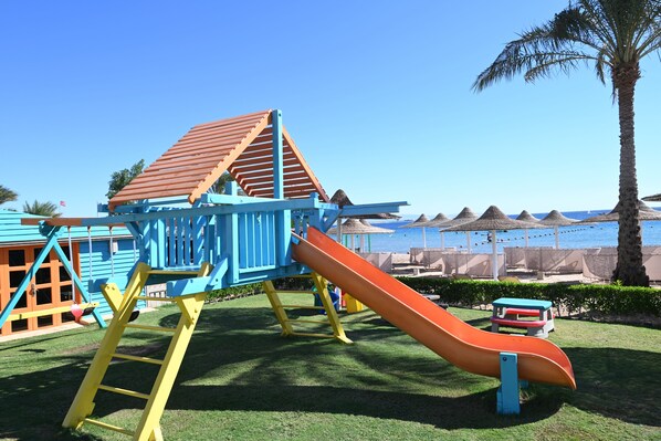 A playground with a slide and climbing structure, set against a beach backdrop. - JAZ Dahabeya (Dahab)