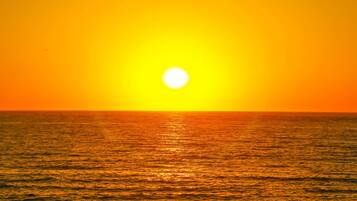 A sunset over the ocean with a clear sky.