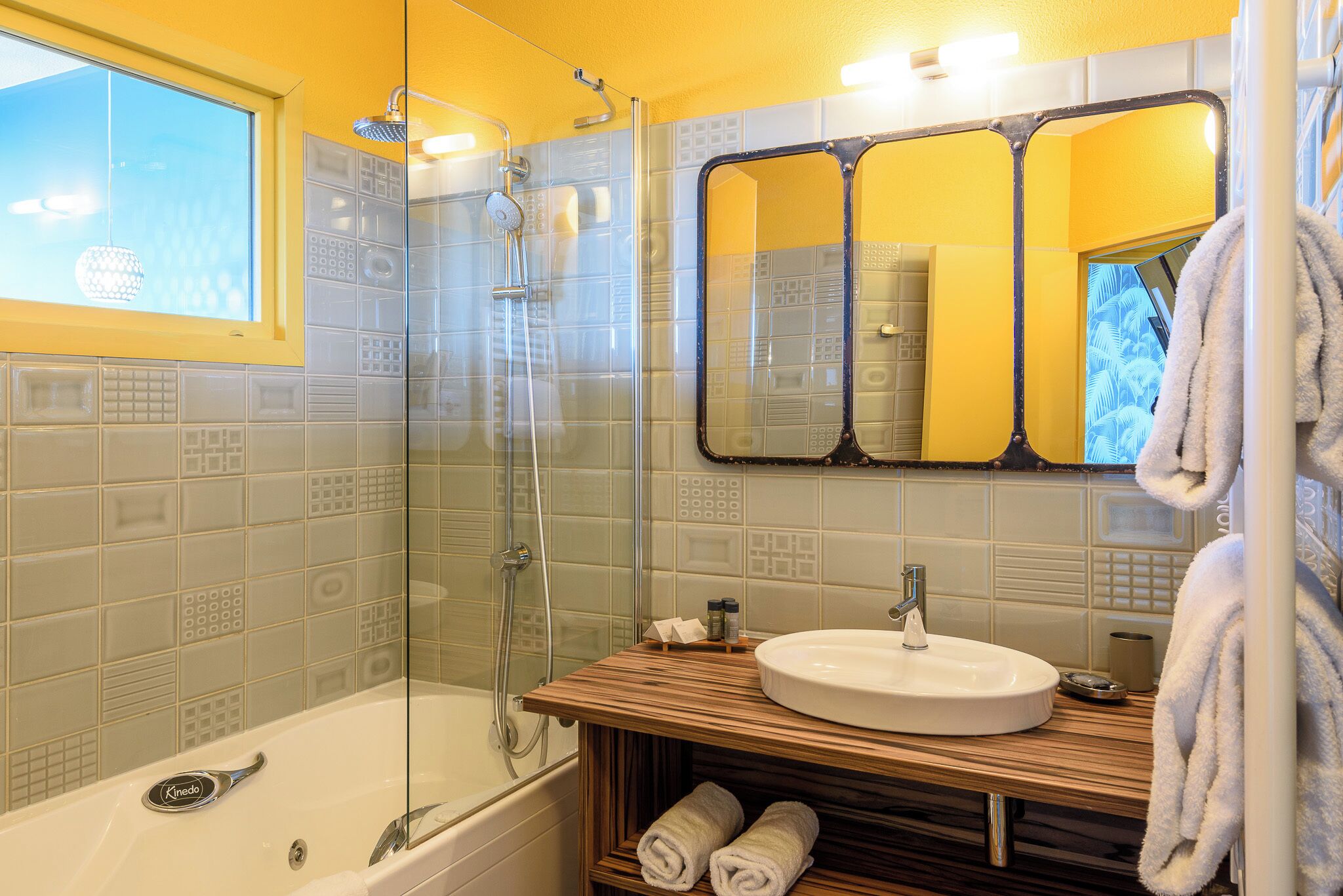 A bathroom with a bathtub, a glass-enclosed shower, a sink, and a mirror.