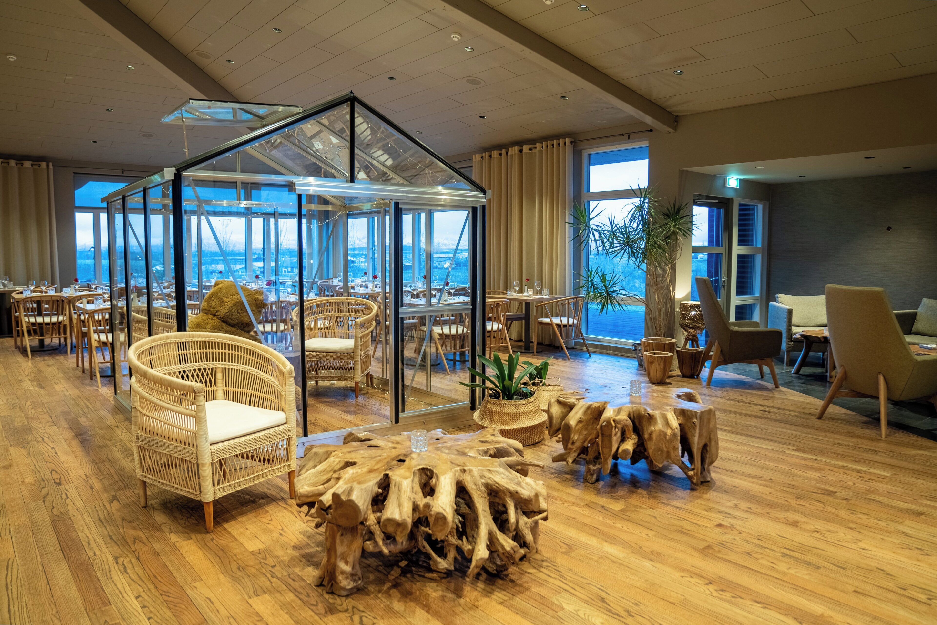 A spacious room with a glass gazebo, wicker furniture, and a view of a snowy landscape.