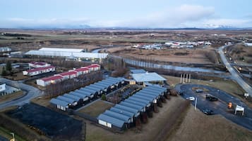 An industrial area with multiple buildings, including a large warehouse and several smaller structures with red roofs.