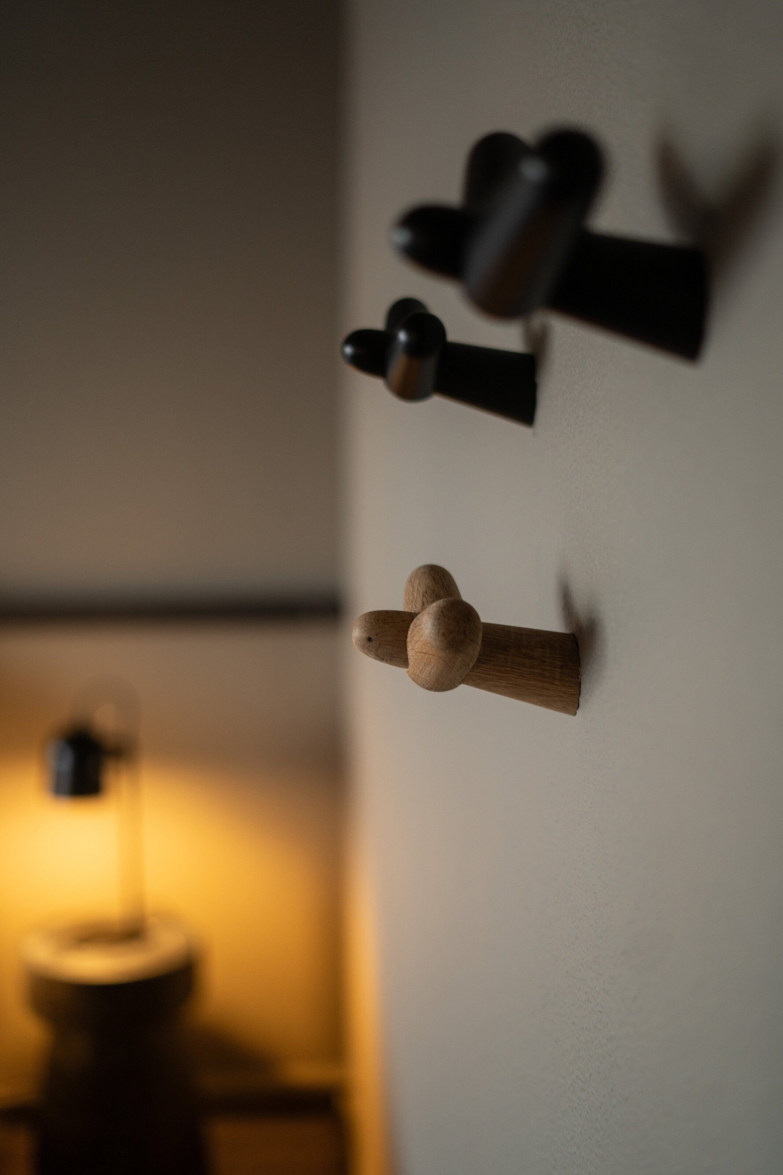 Un objeto de madera fijado a la pared con forma esférica en la parte superior, posiblemente decorativo o funcional.