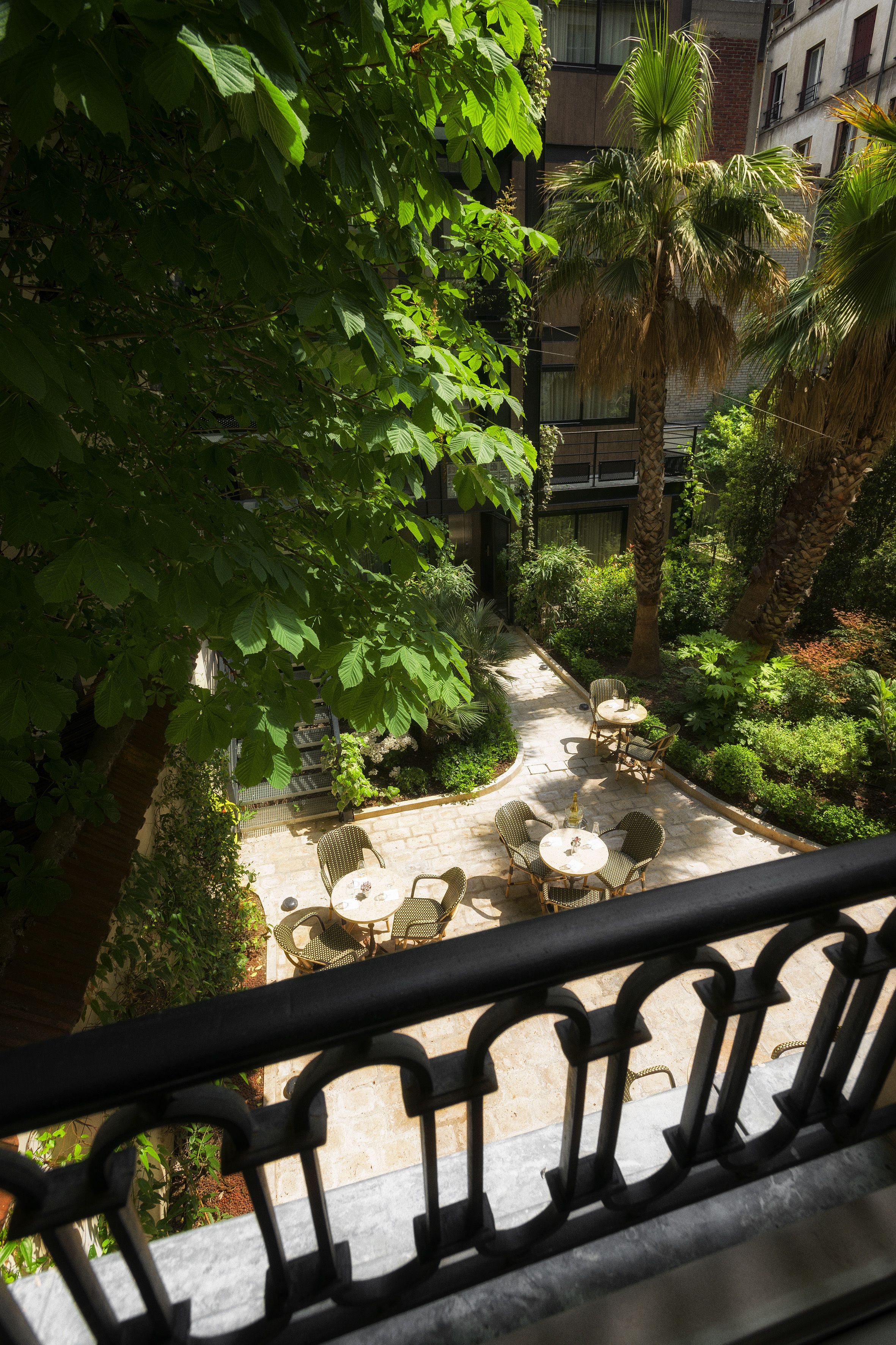 Un cortile con posti a sedere all'aperto, circondato da vegetazione lussureggiante e palme.