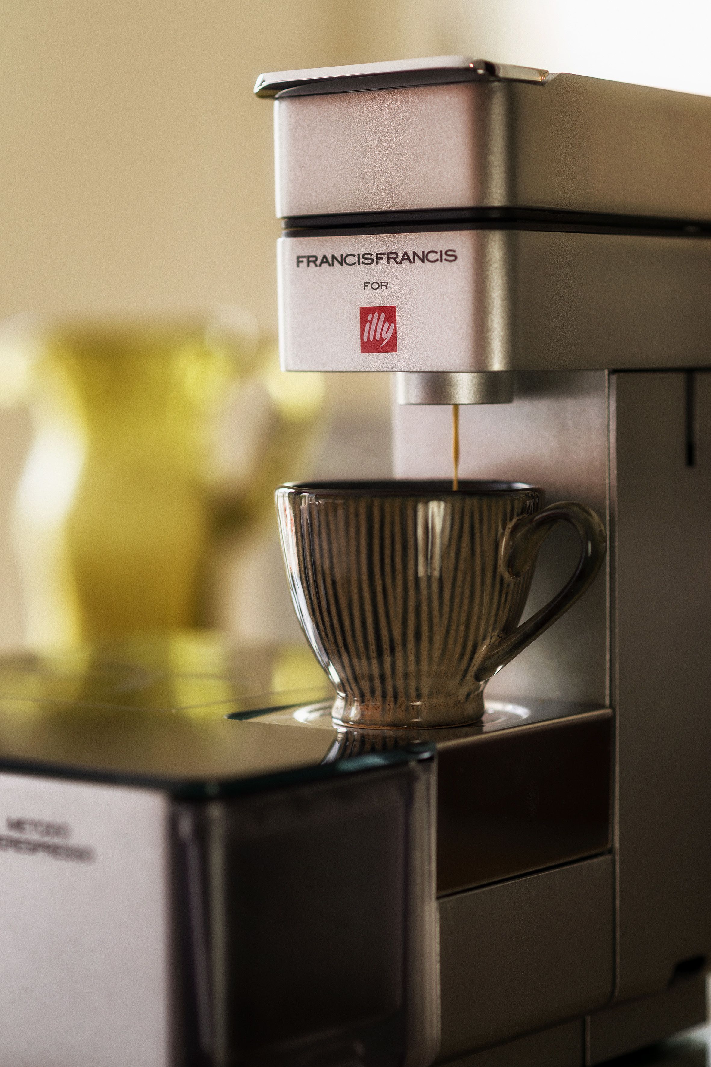 A coffee machine with a glass cup underneath, dispensing coffee.