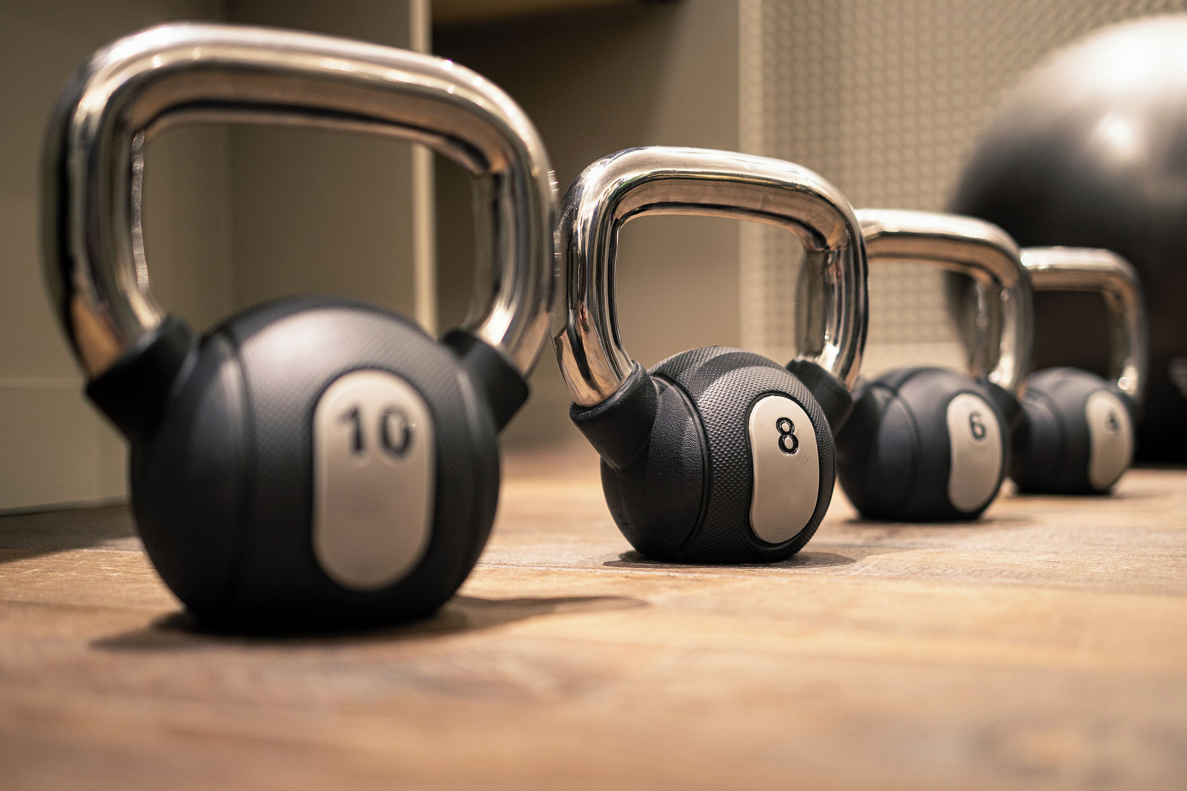 A row of kettlebells with weights labeled 6, 8, and 10.