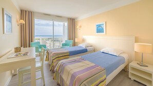 Ett hotellrum med två sängar, ett skrivbord och en stol.