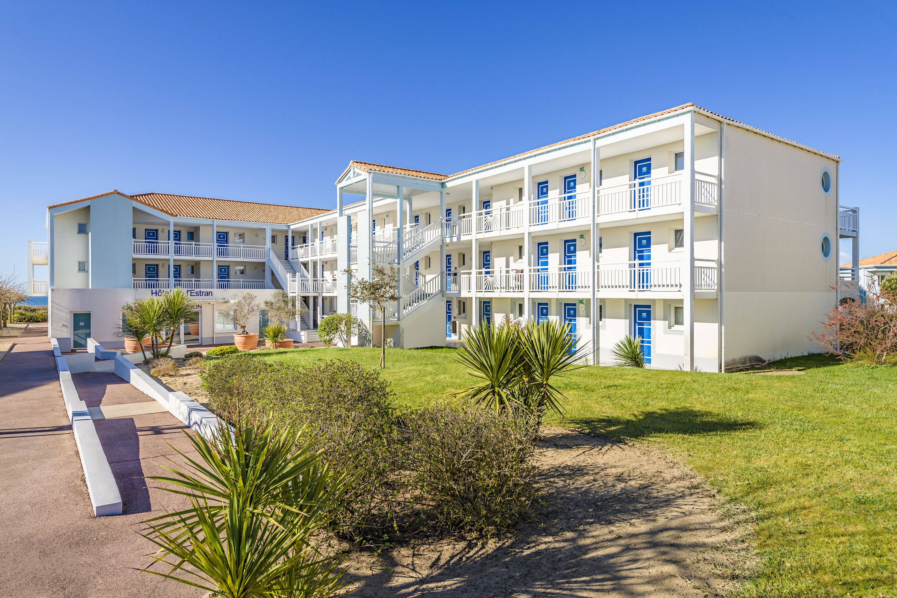 A hotel with multiple floors, balconies, and a central staircase.
