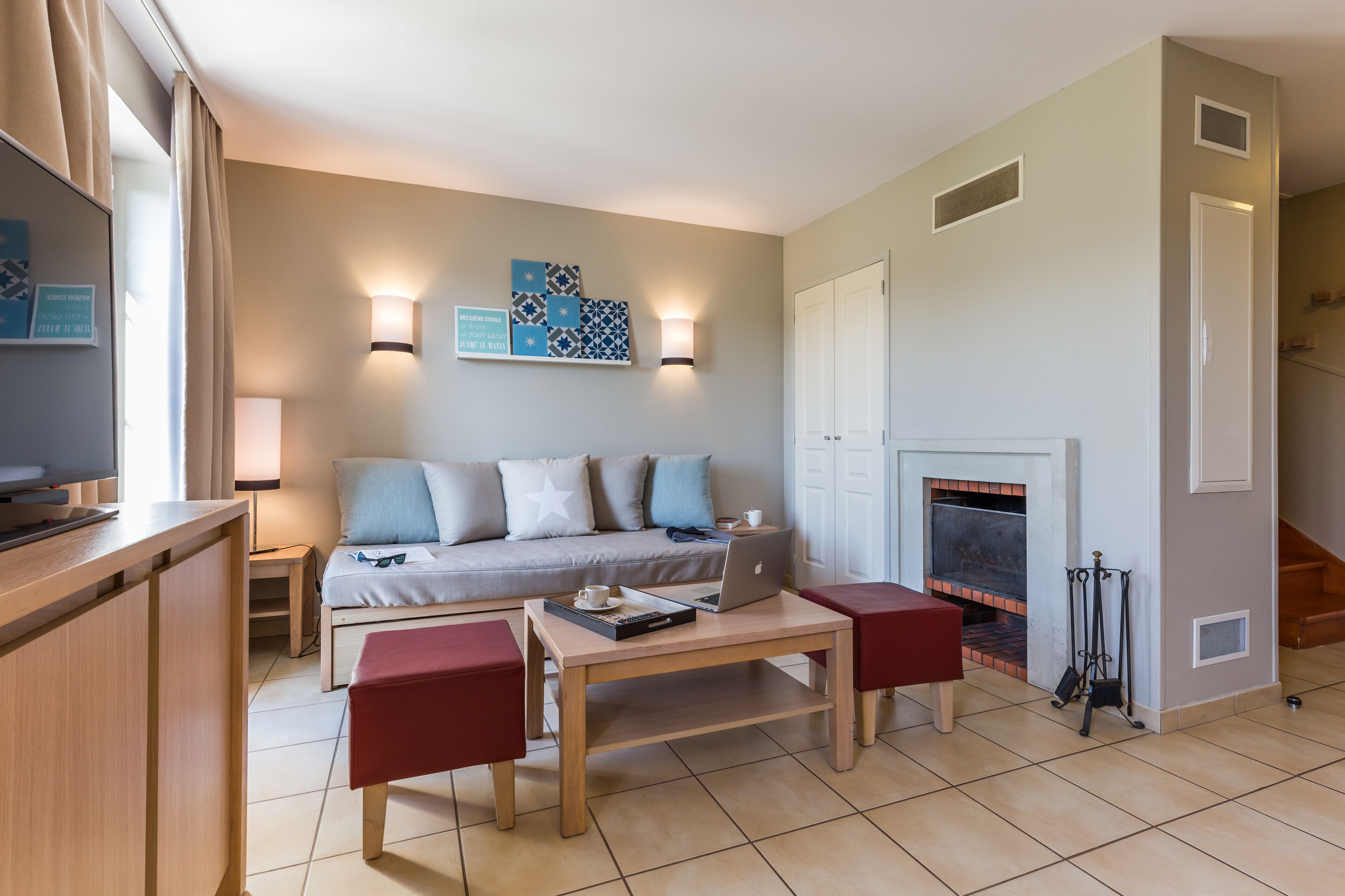 A modern living room with a sofa, a coffee table, and a fireplace.
