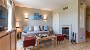 A modern living room with a sofa, a coffee table, and a fireplace.