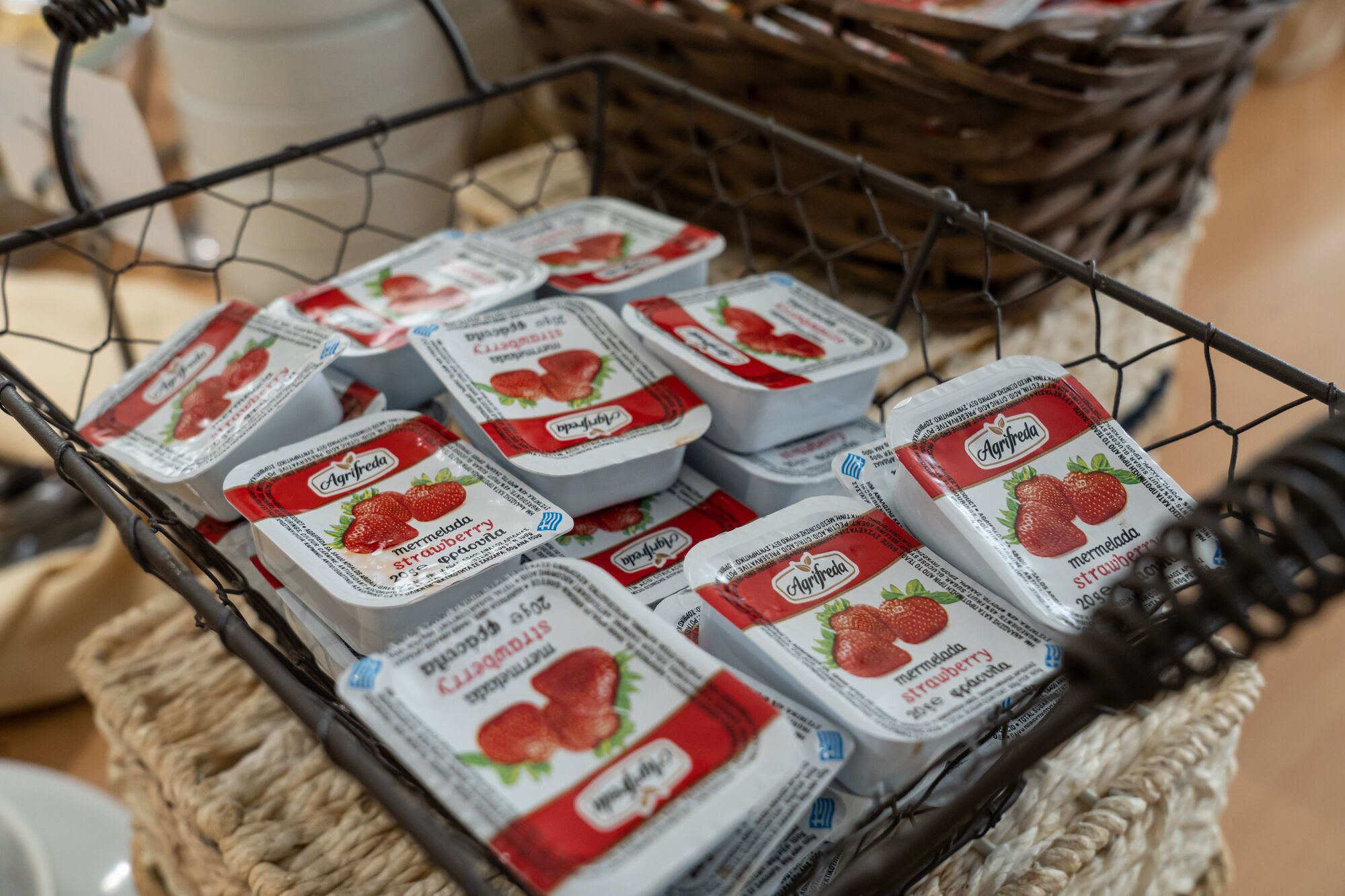 A basket containing multiple containers of strawberry yogurt.