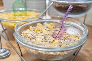 A buffet with various food items in clear glass bowls, including oats and other grains. - Four Seasons Hotel (Glyfada)