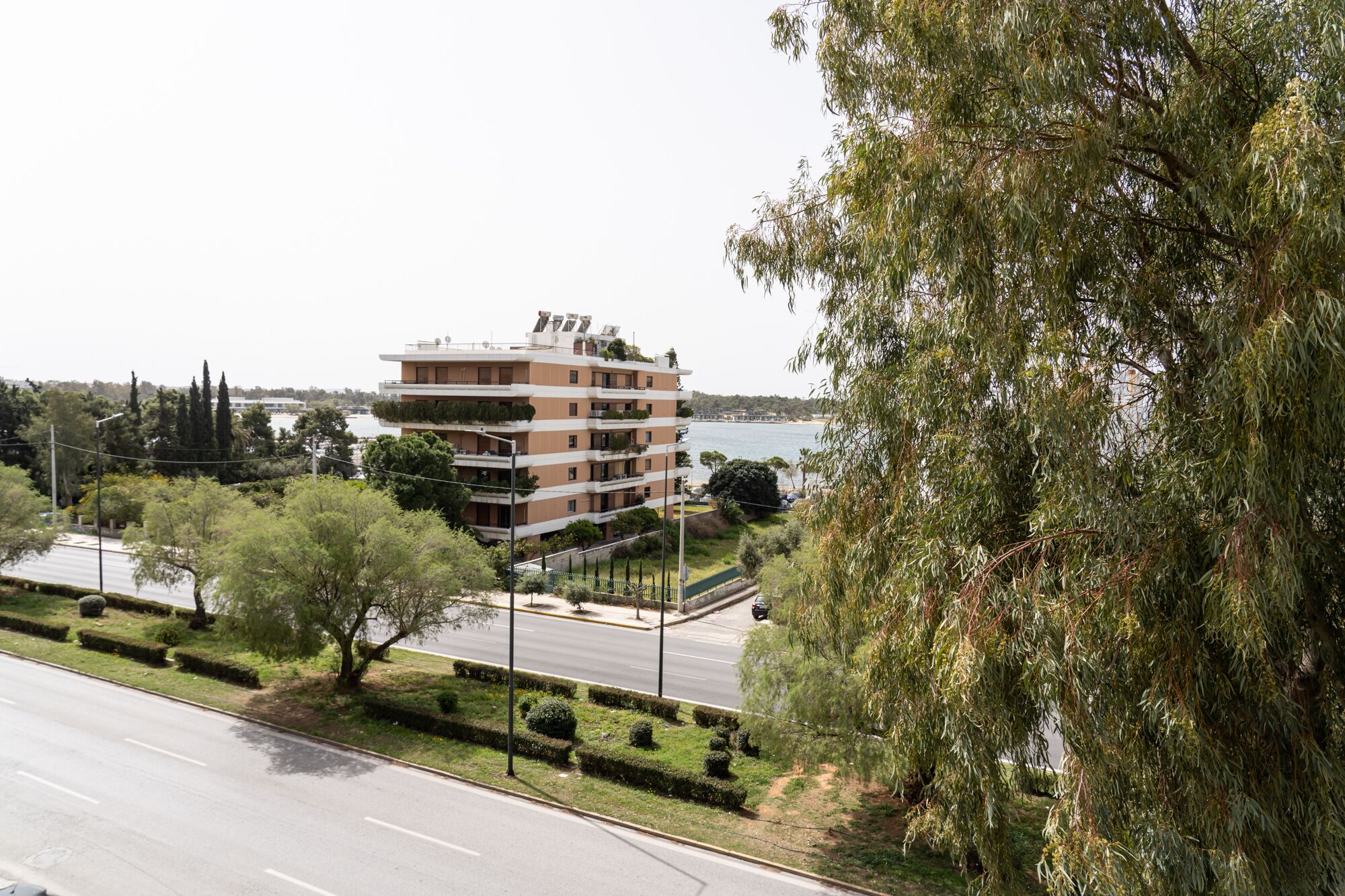 A multi-story building with balconies, located near a body of water.