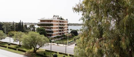A multi-story building with balconies, located near a body of water.