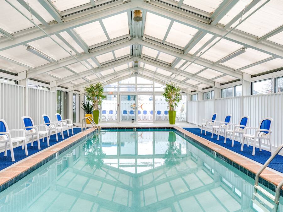 Una piscina techada, sillones reclinables de piscina