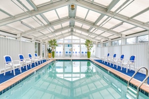 Una piscina techada, sillones reclinables de piscina