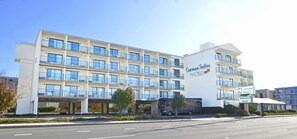 A multi-story hotel with a prominent sign reading "Cayman Suites." - Cayman Suites Hotel (Ocean City)