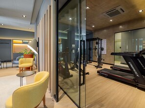 A modern gym with exercise equipment, a treadmill, and a glass wall. - ibis Navegantes Itajai (Itajai)