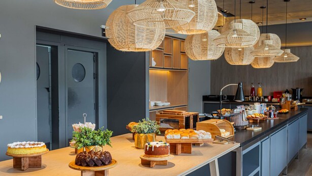 Una cocina moderna con una encimera larga que exhibe una variedad de productos horneados y pasteles.