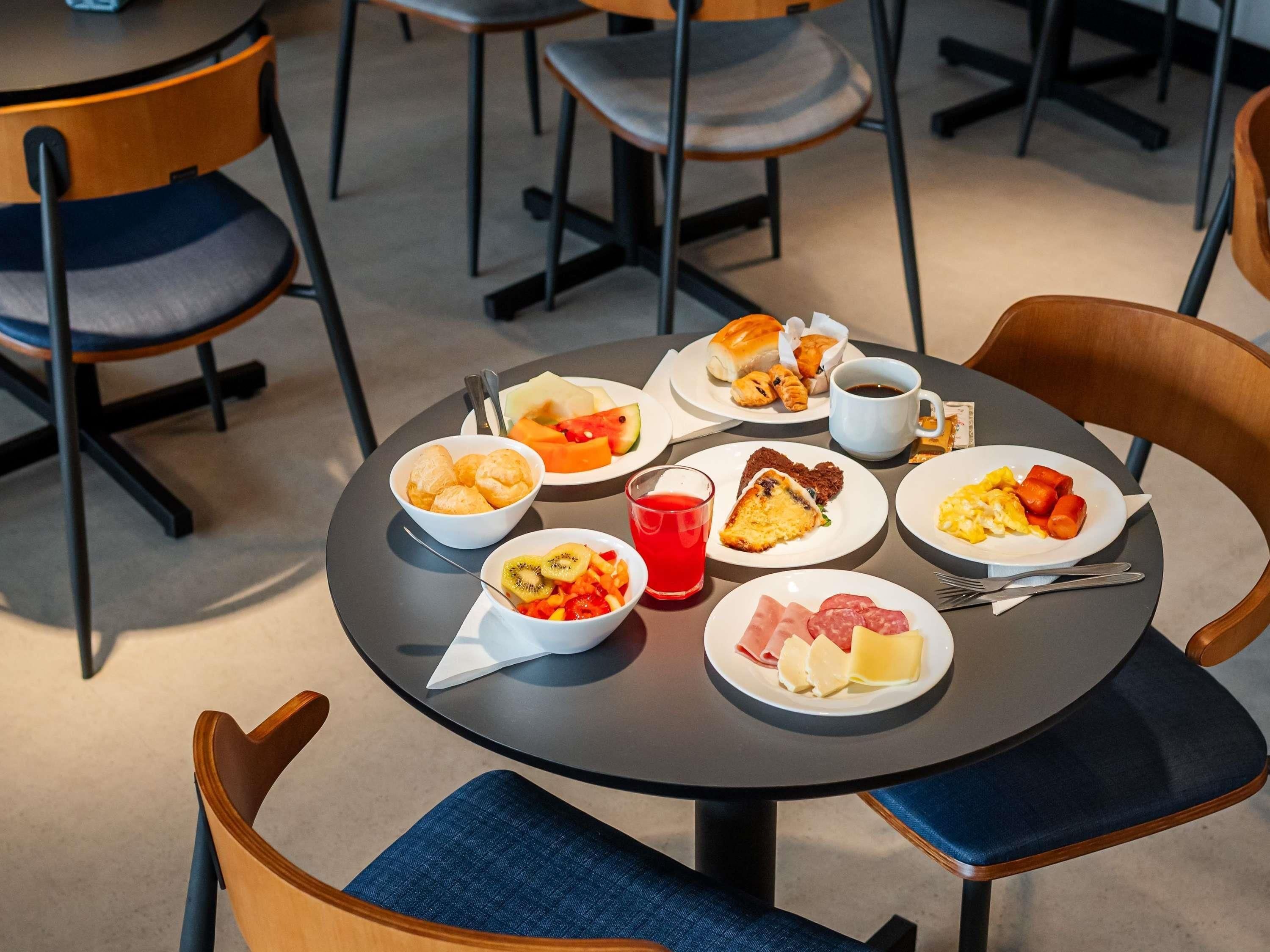 A round table with breakfast items including pastries, fruit, and eggs.