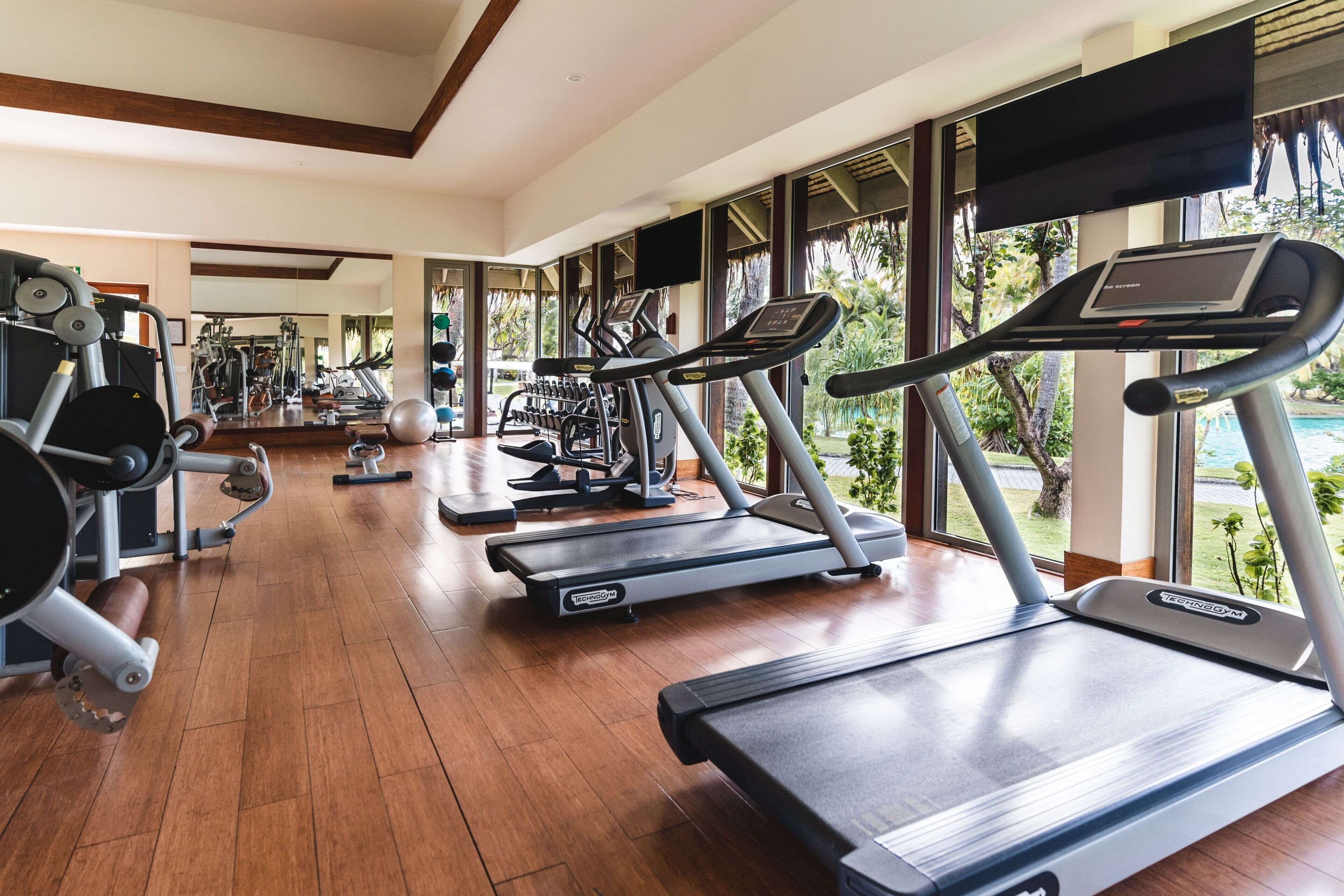 Ein Fitnessstudio mit Laufbändern, Kraftgeräten und Trainingsbällen.