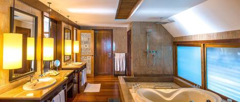 A modern bathroom with two sinks, a large bathtub, and a shower.