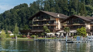 Un hotel con varios balcones, un muelle y vistas al lago.