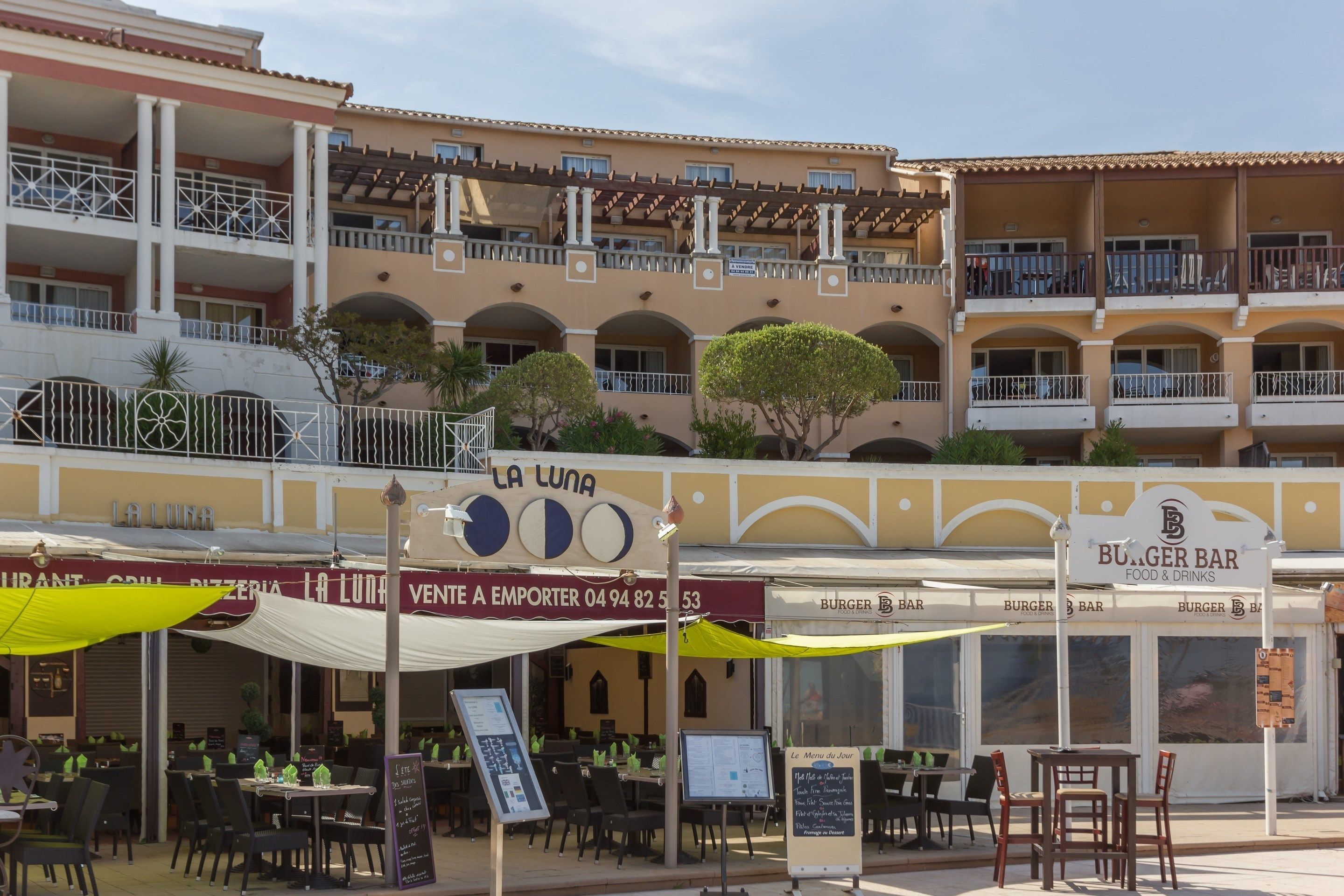 A restaurant named 'La Luna' with outdoor seating and a 'Burger Bar' adjacent to it.