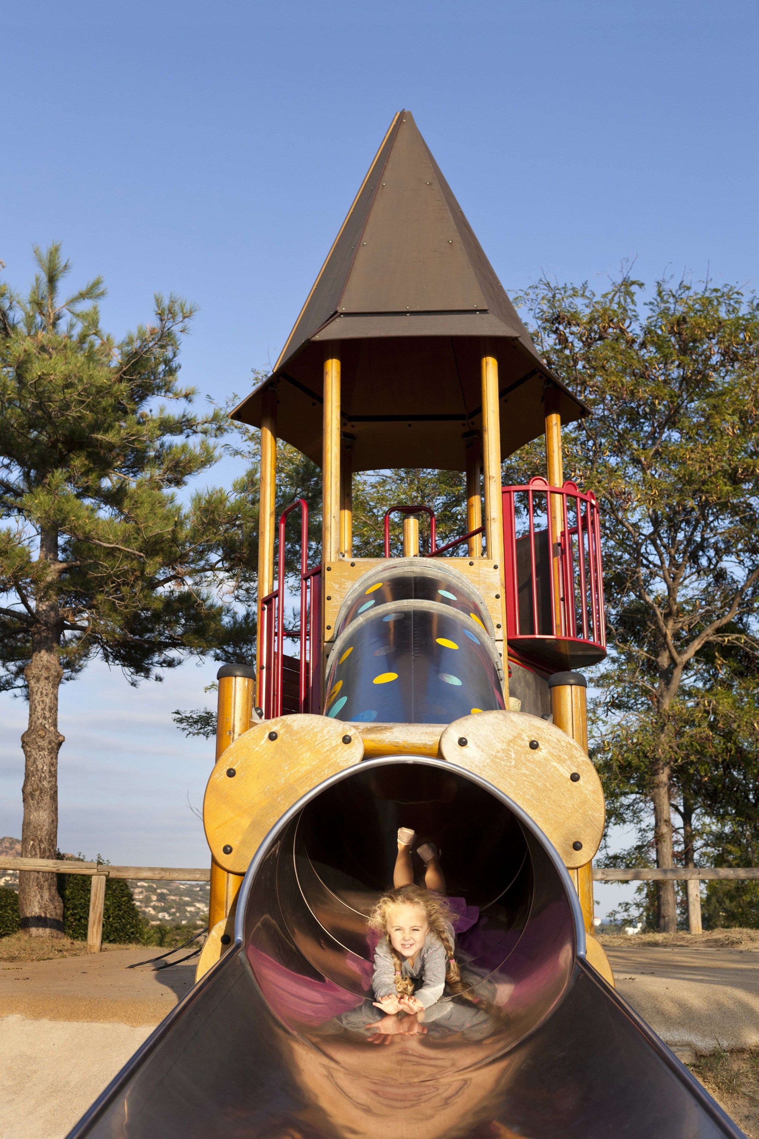 A playground with a slide, climbing structures, and a lookout tower.