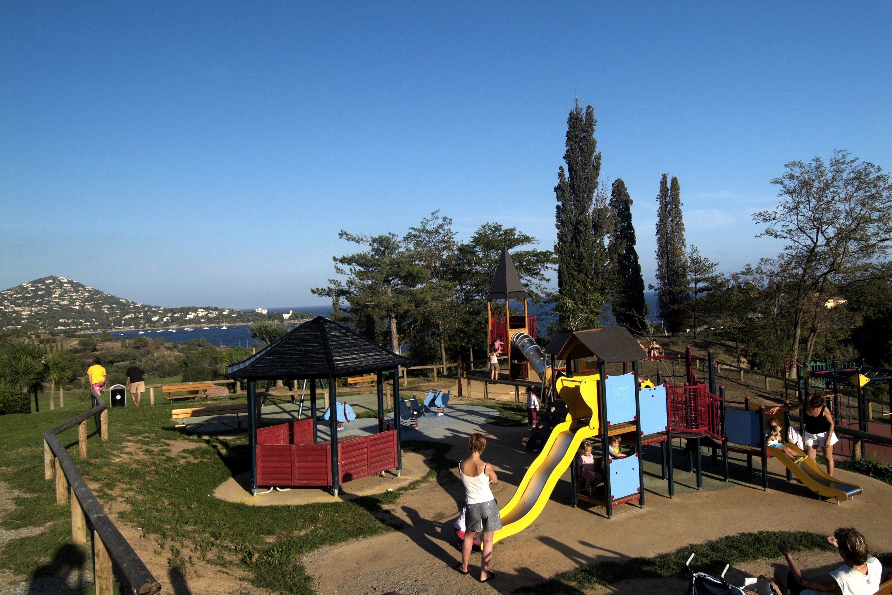 A playground with a slide, benches, and a gazebo.