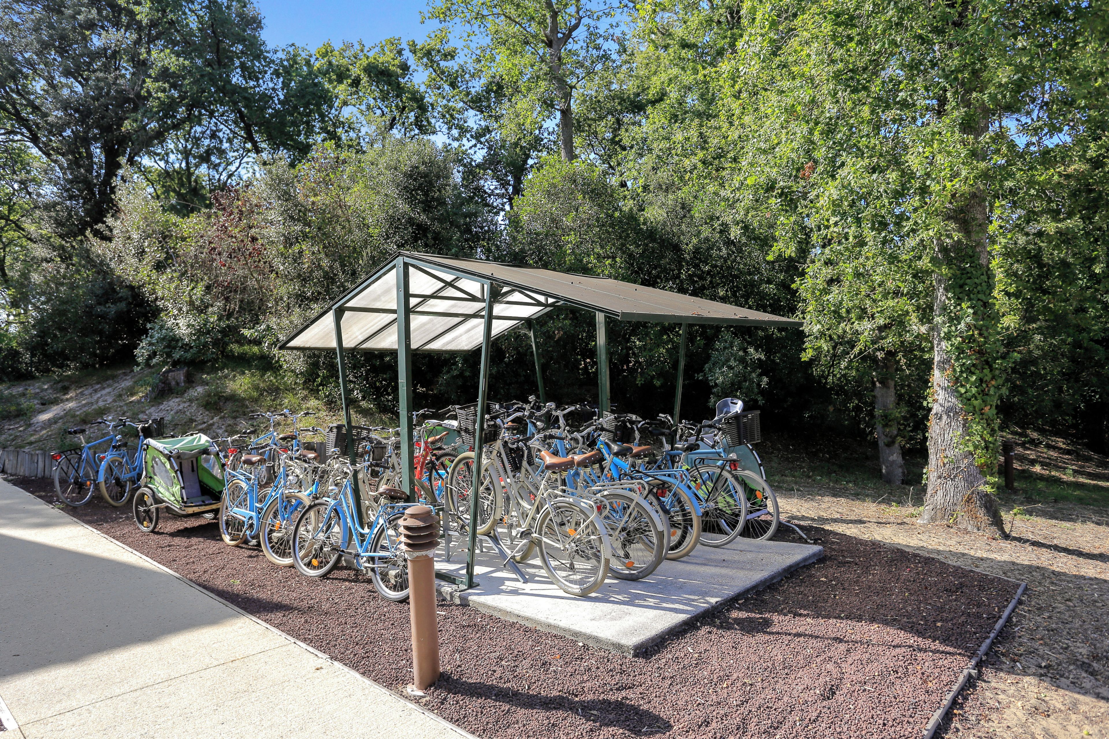 Uma área coberta para estacionamento de bicicletas com várias bicicletas.