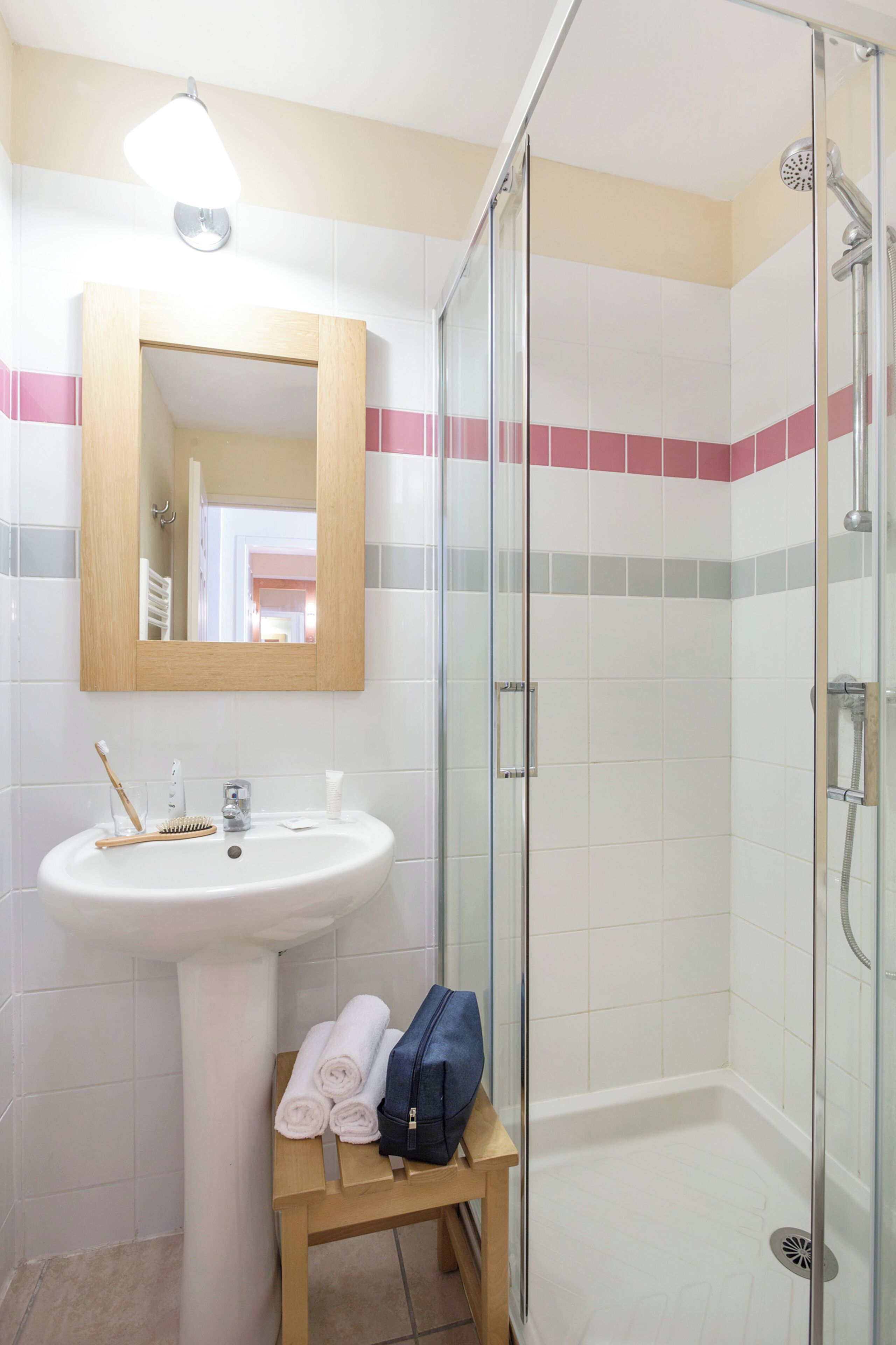 Une salle de bain avec un lavabo, un miroir et une douche.