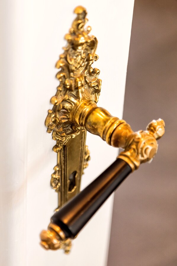 A close-up of an ornate brass door handle with intricate designs.