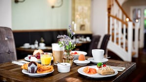 A breakfast table with croissants, smoked salmon, and a vase of flowers.
