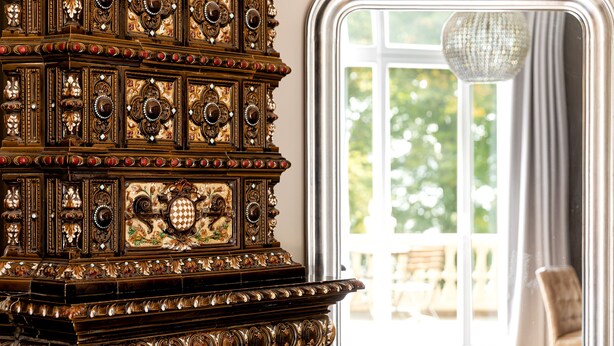 A richly decorated wooden piece of furniture with intricate carvings and a chandelier.