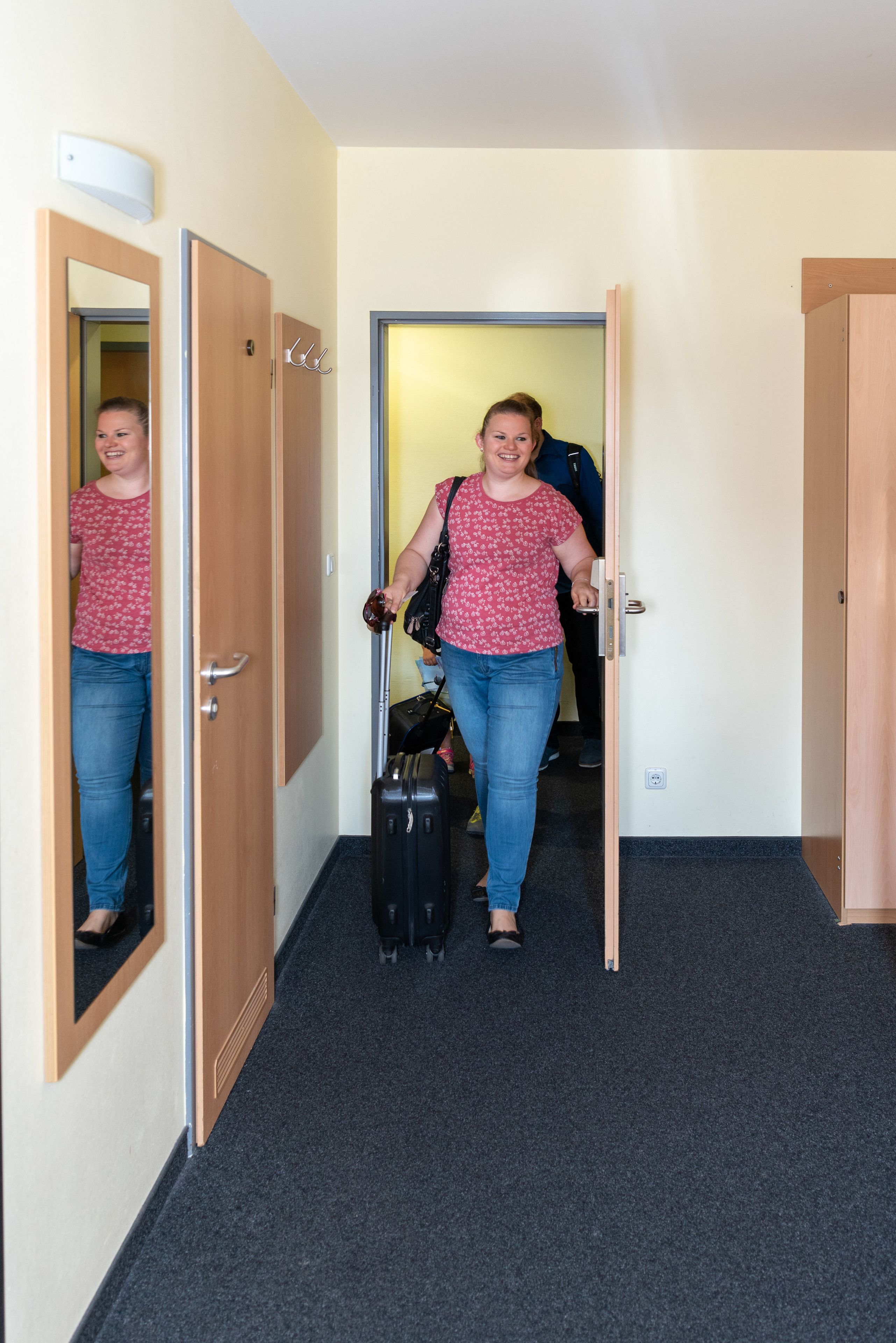 A hallway with wooden doors and a carpeted floor.