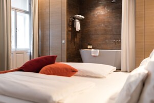 Un bagno moderno con una vasca, un porta asciugamani e un soffione.