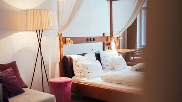A modern bedroom with a wooden headboard, white bedding, a bedside table, and a floor lamp.