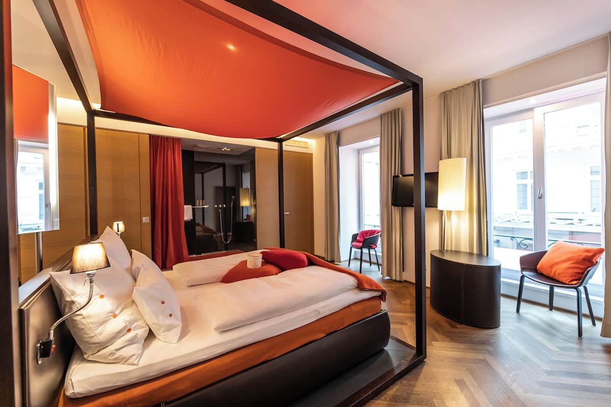 Una habitación de hotel moderna con una cama grande, un escritorio y una silla.