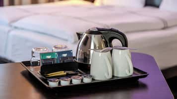 Una bandeja con cafetera, dos tazas y diferentes cápsulas de café sobre una mesa en una habitación de hotel.
