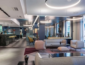 A modern interior with a bar area, seating, and a large window. - Premier Inn Wien City Hauptbahnhof (Vienna)