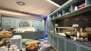 A breakfast buffet with various food items and a coffee station.