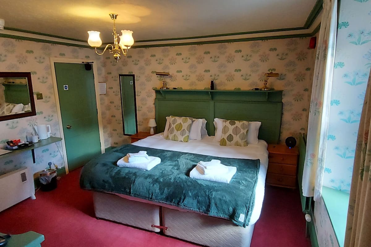 Ein Schlafzimmer mit Bett, Schminktisch, Spiegel und einer Chandelier.