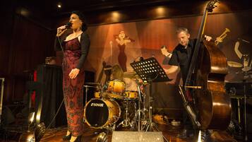 Een podium met een zanger, een contrabassist en een drummer.
