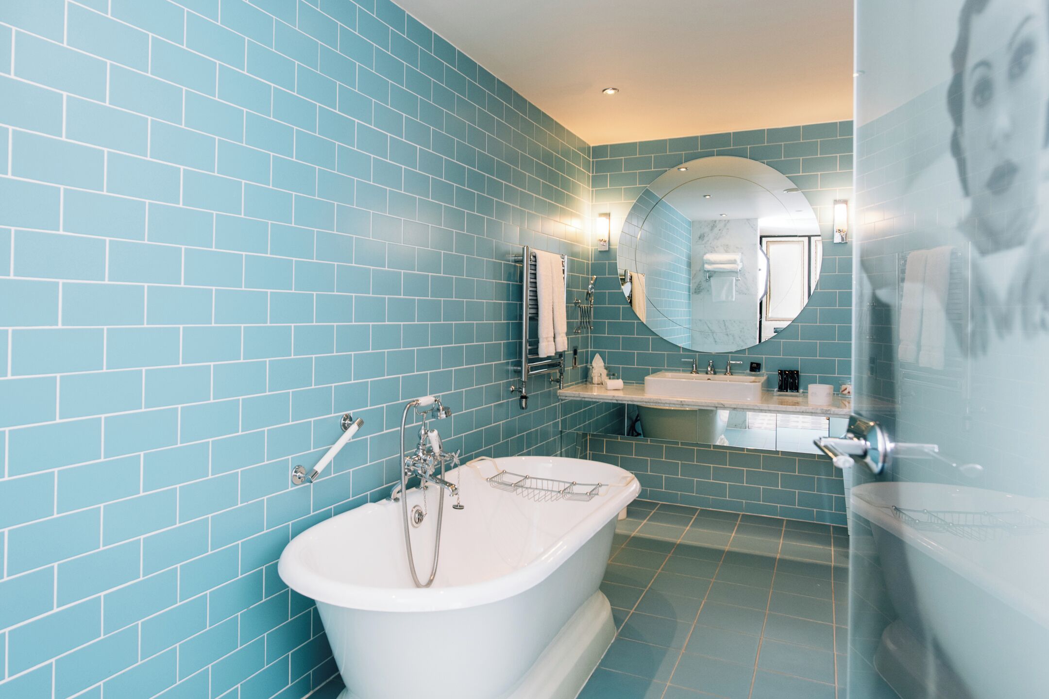 A bathroom with a large bathtub, a sink, and a mirror.