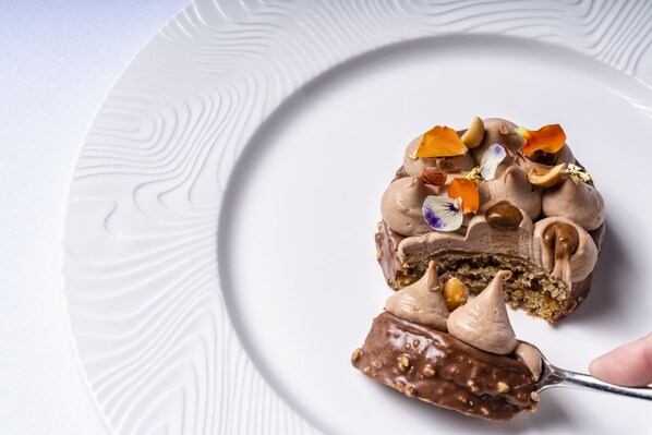Un dessert servi dans une assiette blanche dont le bord est légèrement texturé.