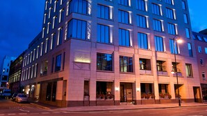 A modern hotel with a symmetrical facade, large windows, and a prominent entrance.