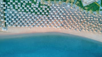Una playa cerca, sillas reclinables de playa, sombrillas