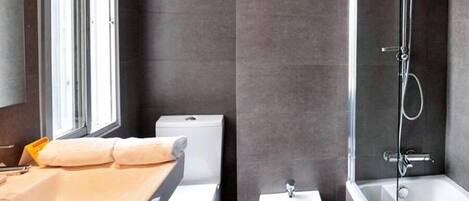 A modern bathroom with a toilet, sink, and shower.