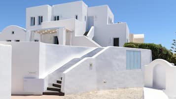 A white building with a staircase leading to a door marked "Guest Only."