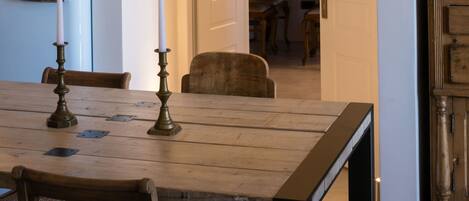 A dining area with a wooden table, chairs, and a vintage-style refrigerator.